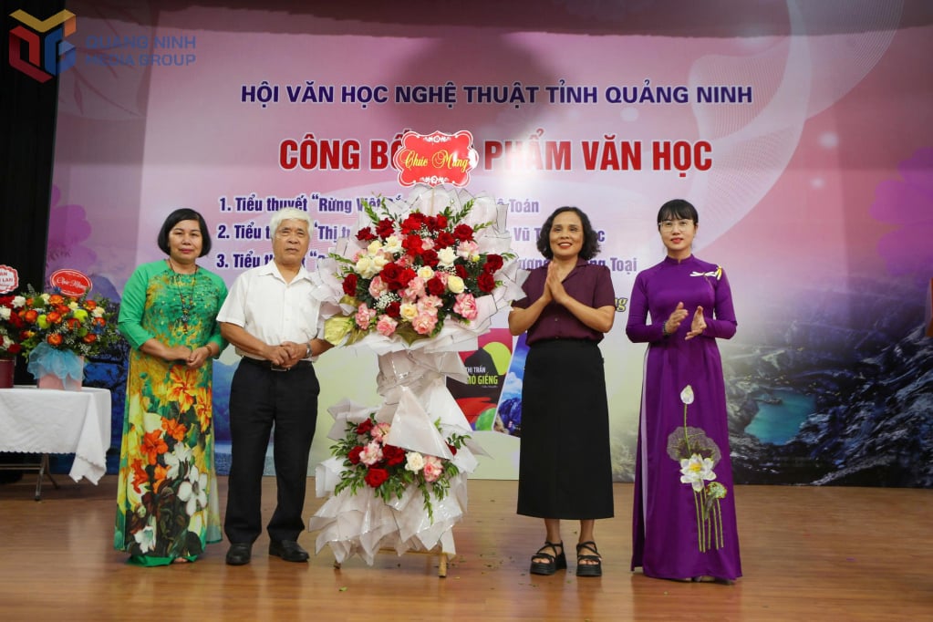 Đại diện Uỷ ban MTTQ tỉnh tặng hoa chúc mừng các tác giả.