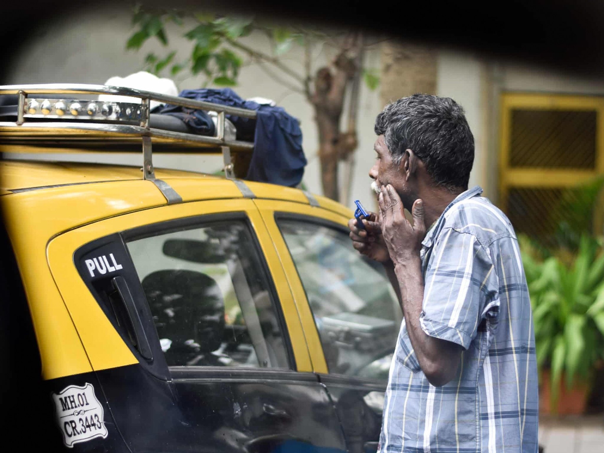 &quot;Nghi thức&quot; buổi sáng của một tài xế taxi ở Mumbai, Ấn Độ được phản chiếu qua gương chiếu hậu. Ảnh: Sachin Kr.