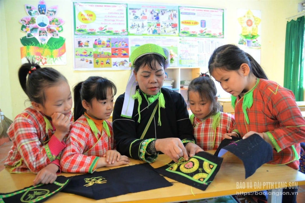 Thành viên Tổ hợp tác Nghề thêu, dệt dân tộc Nùng Phàn Sình Hải Yến hướng dẫn các em học sinh trên địa bàn kỹ năng thêu truyền thống 