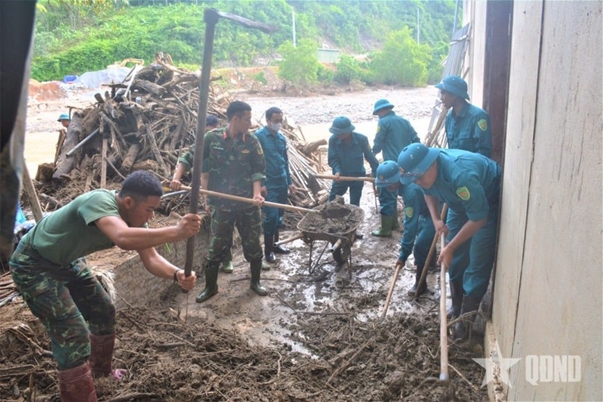 Cán bộ, chiến sĩ Trung đoàn 764 và dân quân xã Mường Xén (Nghệ An) giúp các hộ dân dọn dẹp sau lũ. 