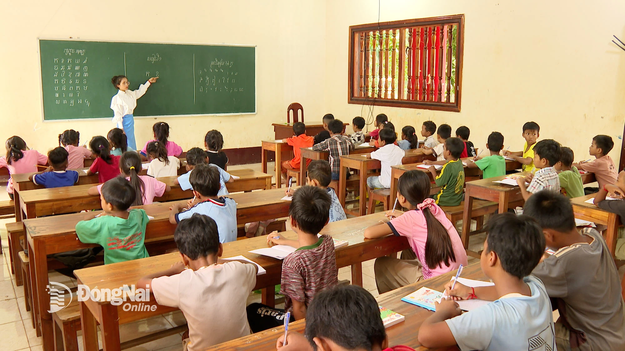 Em Thị Sập Hắt đứng lớp hướng dẫn đọc và viết chữ khmer cho các em tại chùa Sóc Lớn. Ảnh: Từ Huy
