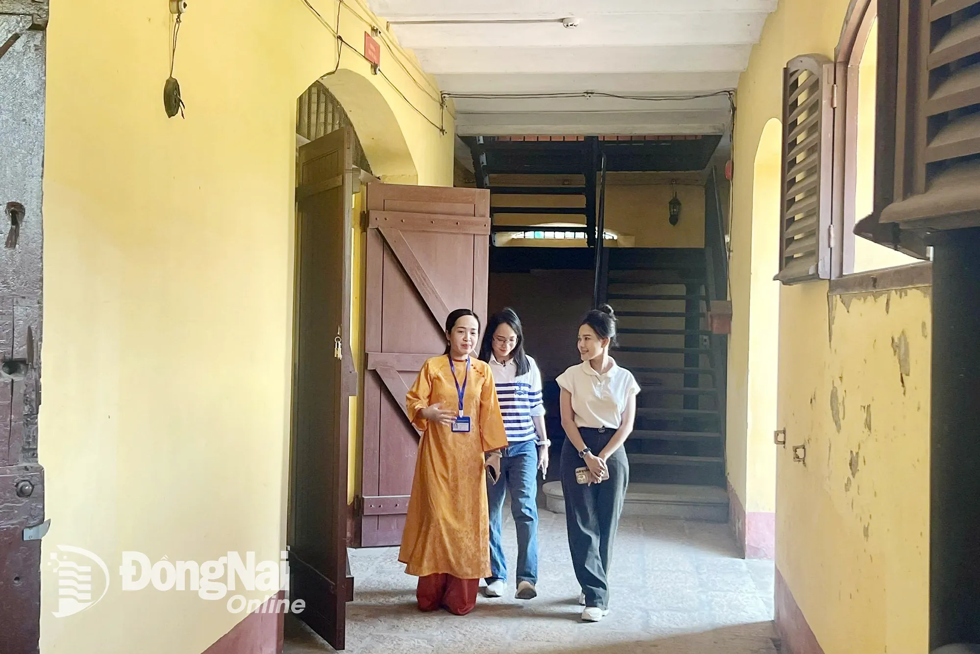 สมาชิกมรดก Pham Thi Hong Tuoi (ในชุดอ่าวหญ่าย) แนะนำพิธีกร 2 ท่านของรายการภายในป้อมปราการด้านตะวันออก ภาพโดย: Minh Chi