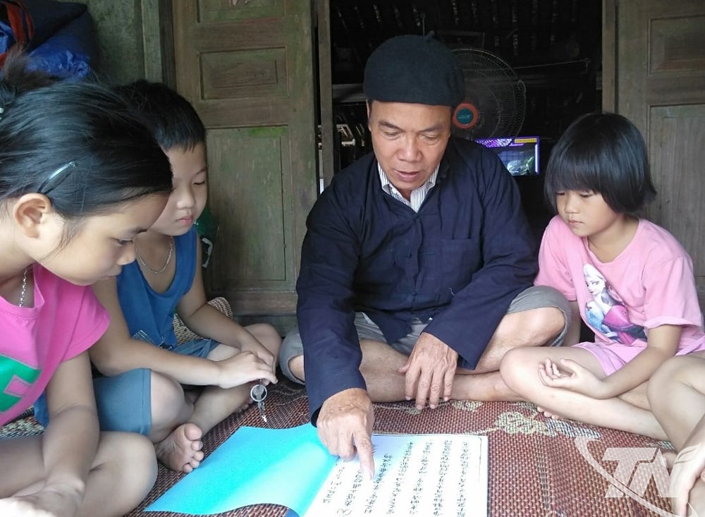  Ông Chu Văn Cam, xóm Đồng Luông, xã Quang Sơn, hướng dẫn các cháu học chữ nôm Nùng.