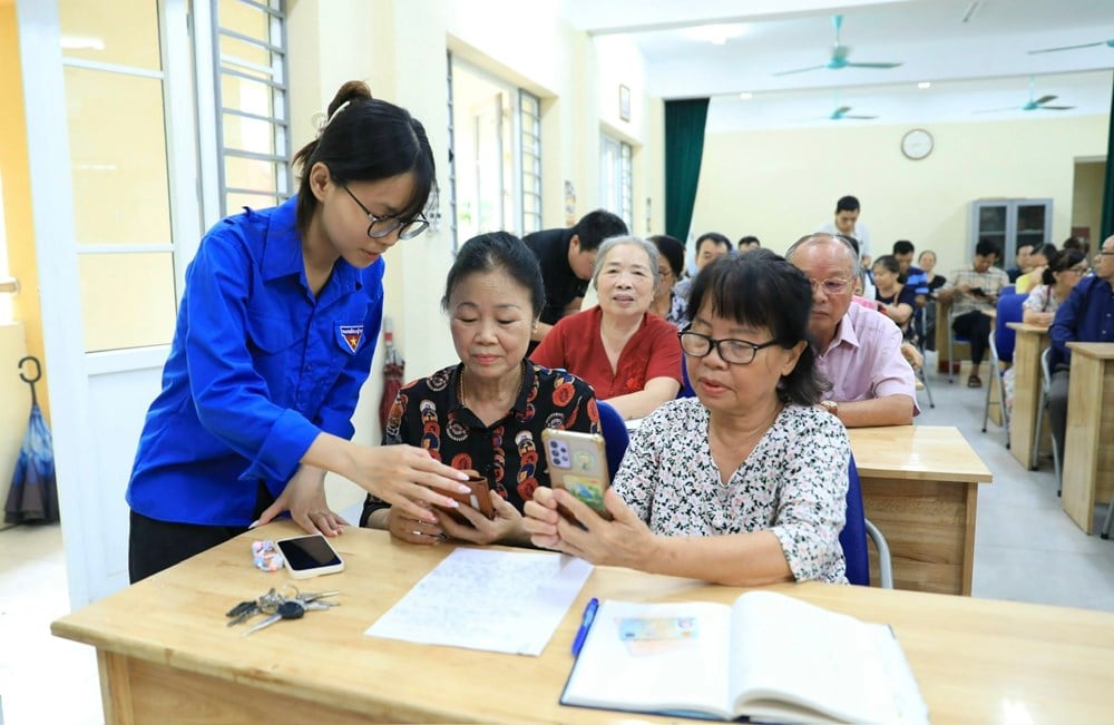 Youth Union members of Tay Ho ward guide cadres and party members to install the application to perform Party administrative procedures. Photo: Quang Thai