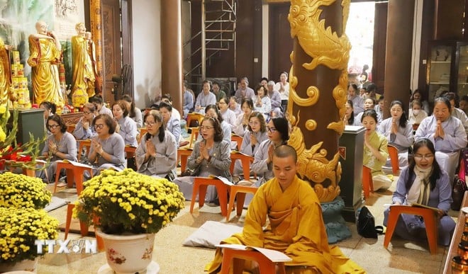 Các Phật tử thực hiện nghi lễ cầu an, tụng kinh, niệm Phật tại buổi lễ. (Ảnh: Xuân Tú/ TTXVN)