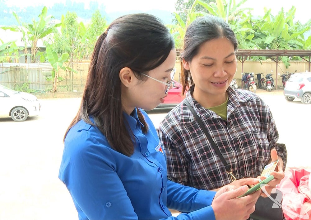 Thanh niên hướng dẫn người dân sử dụng các ứng dụng thanh toán trên điện thoại thông minh.