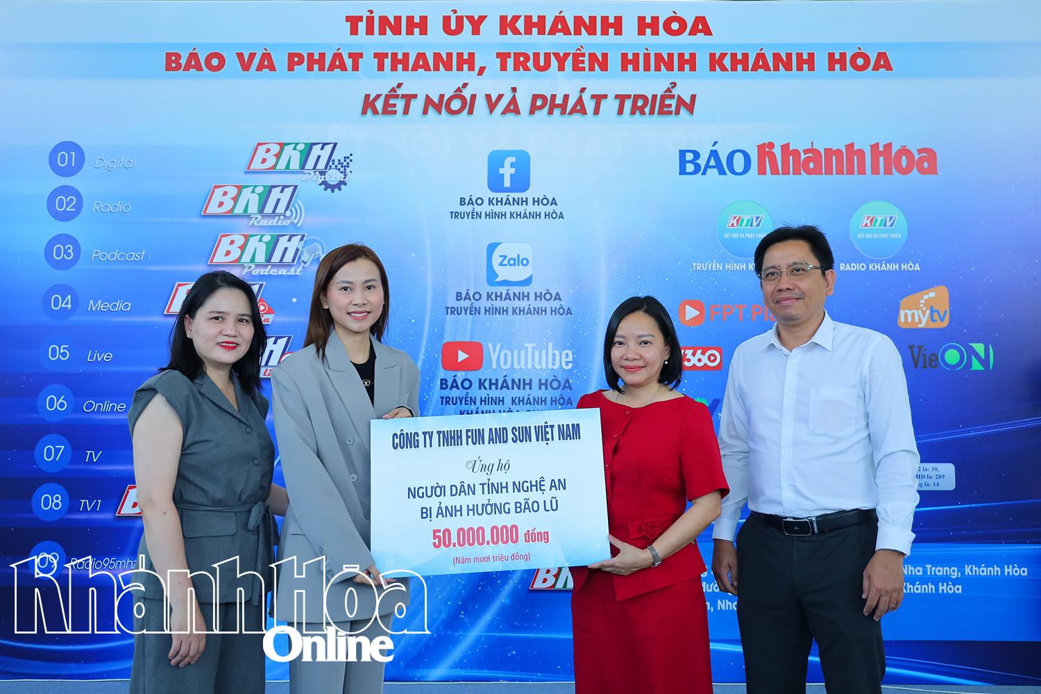 Lãnh đạo Báo và Phát thanh, Truyền hình Khánh Hòa (bên phải) tiếp nhận bảng tượng trưng số kinh phí ủng hộ đồng bào vùng lũ tỉnh Nghệ An.