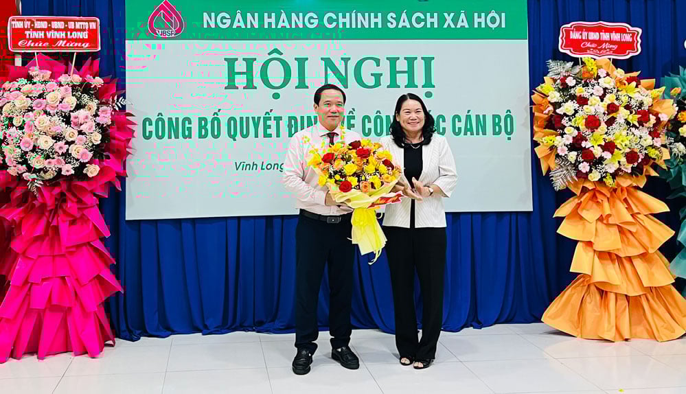 Bà Nguyễn Thị Bé Mười - Tỉnh ủy viên, Phó Chủ tịch UBND tỉnh, Trưởng Ban đại diện HĐQT NHCSXH tỉnh Vĩnh Long tặng hoa chúc mừng Giám đốc chi nhánh NHCSXH tỉnh Lê Hoàng Phi.