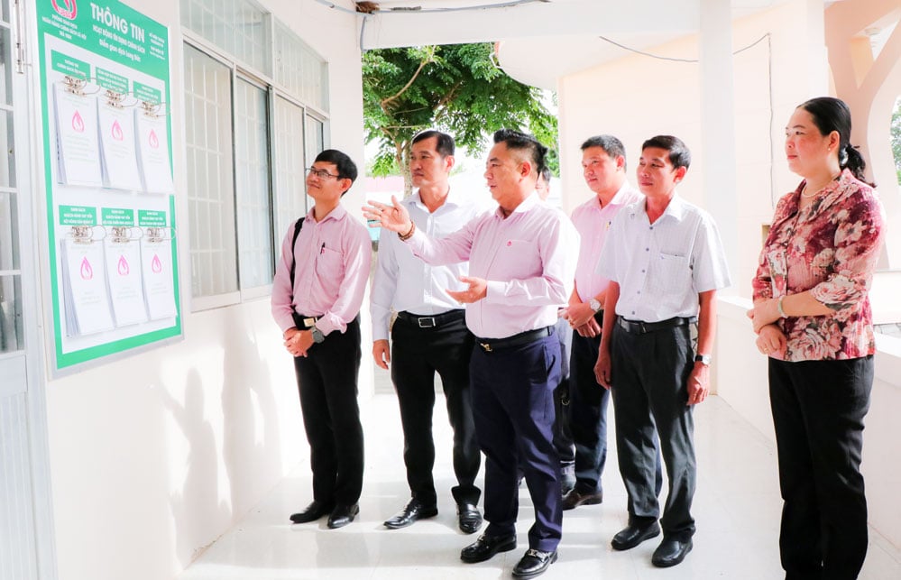 Phó Tổng Giám đốc NHCSXH Huỳnh Văn Thuận kiểm tra bảng niêm yết quy trình, thủ tục tại điểm giao dịch phường Long Đức.