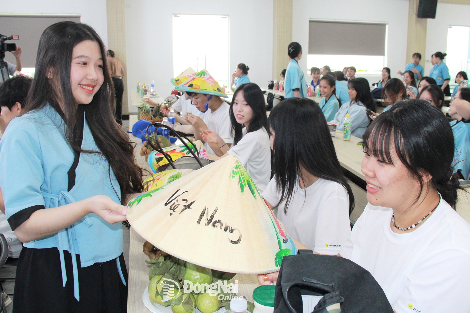 Sinh viên ngành Hàn Quốc học, Khoa Đông Phương, Trường đại học Lạc Hồng (phường Trấn Biên, tỉnh Đồng Nai) tặng nón lá cho thanh, thiếu niên tỉnh Jeollanam tại buổi giao lưu
