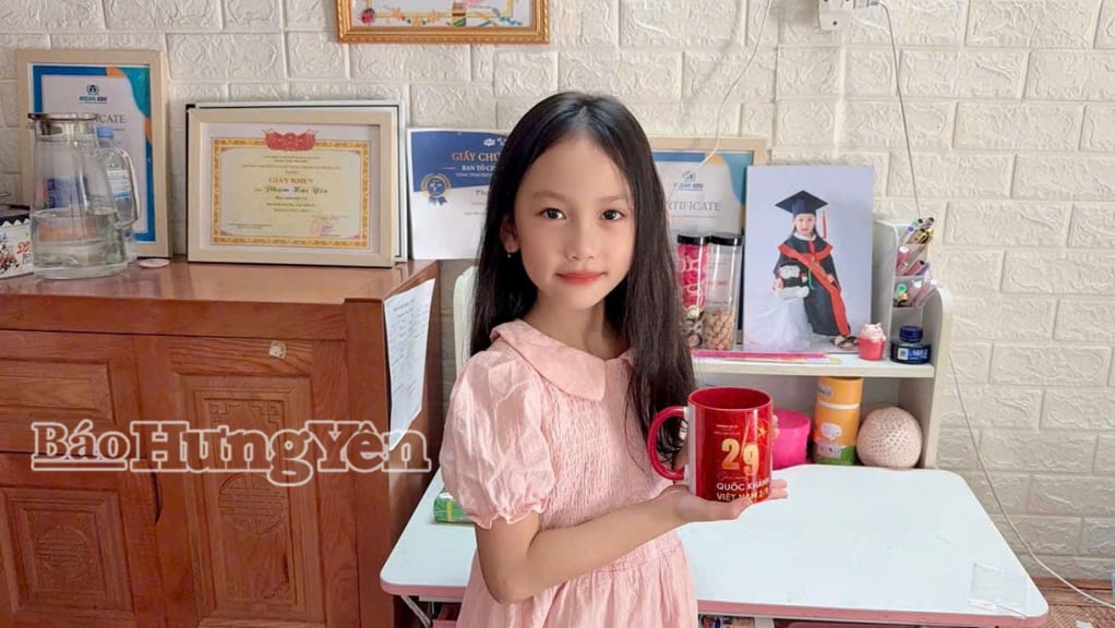 Em Phạm Hải Yến (xã Việt Tiến) vui vẻ khi được sở hữu chiếc cốc in dòng chữ Chúc mừng Ngày Quốc khánh 2/9.