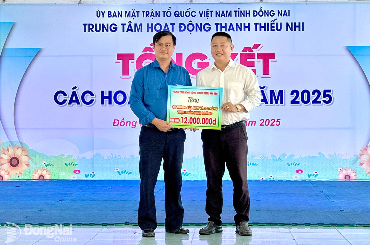 Giám đốc Trung tâm Hoạt động Thanh thiếu nhi tỉnh Bùi Xuân Dũng (bìa phải) trao bảng biểu trưng quà tặng đến Đoàn xã Tân Lợi. Ảnh: Hồng Phương


