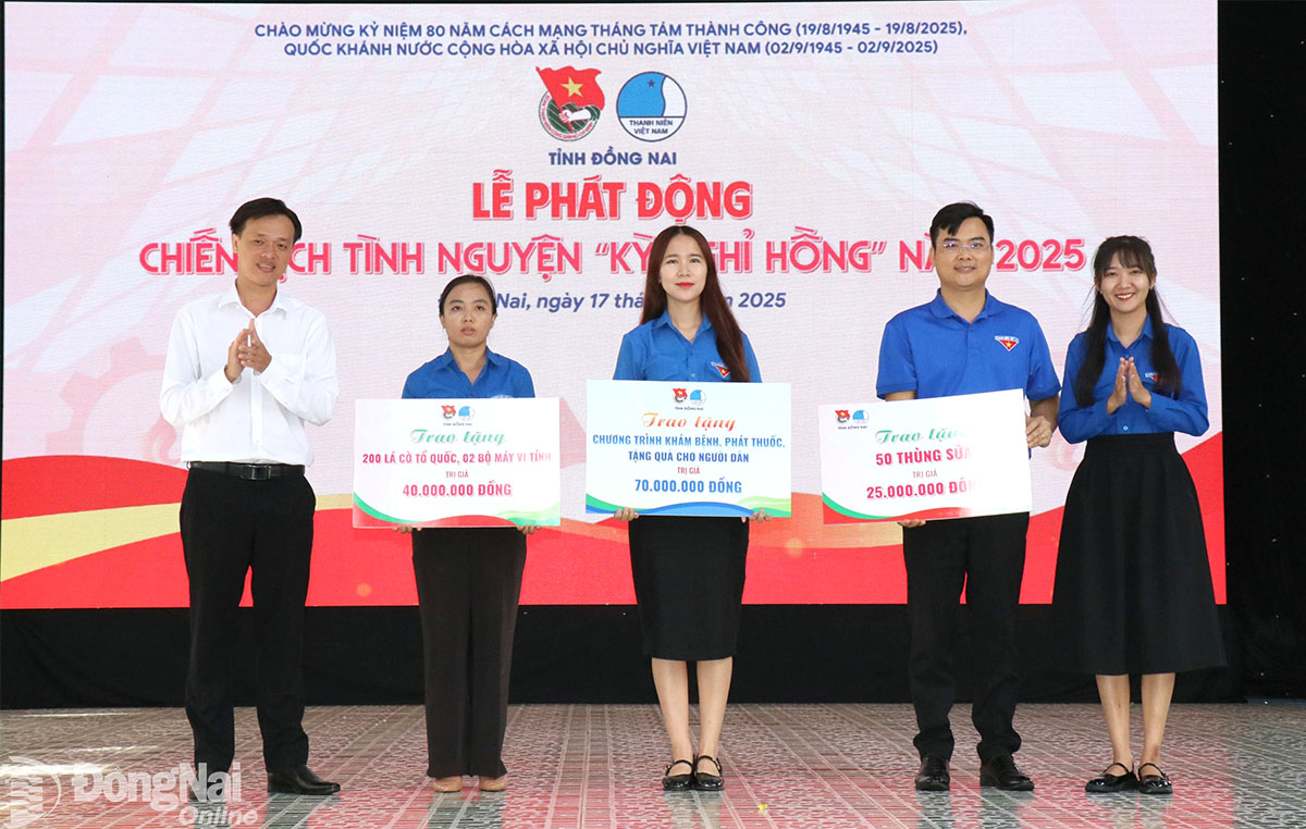 Trao bảng biểu trưng tặng cờ Tổ quốc, máy vi tính và chương trình khám bệnh, phát thuốc, tặng quà cho xã Đăk Ơ và xã Đăk Nhau. Ảnh: Ngọc Huyền
