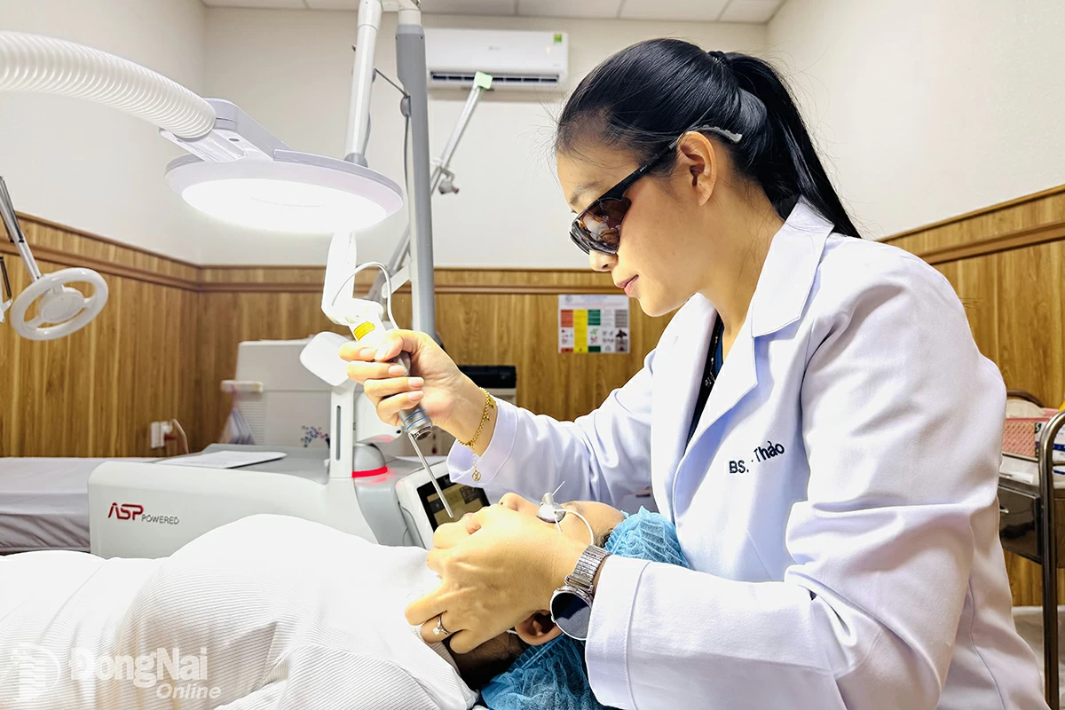 Bác sĩ Bùi Thị Thu Thảo thực hiện kỹ thuật laser điều trị bớt sắc tố da cho bệnh nhân. Ảnh: Hạnh Dung

