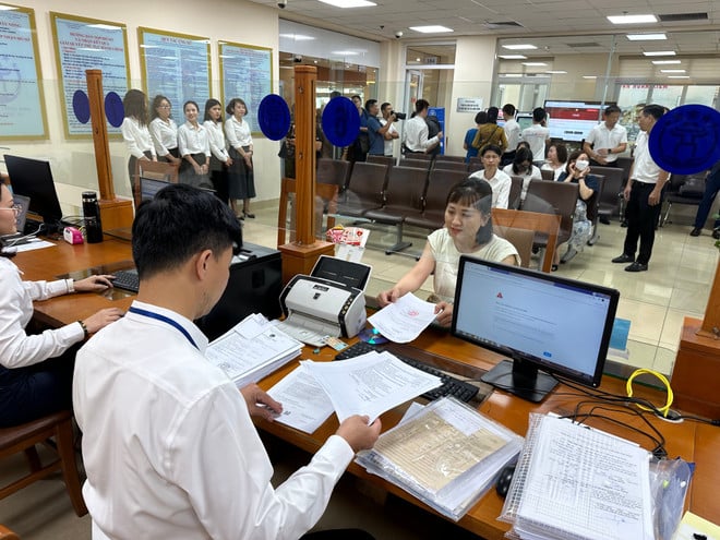 Cán bộ Trung tâm Phục vụ hành chính công Hà Nội tiếp nhận các thủ tục hành chính. (Ảnh: Xuân Quảng/Vietnam+)
