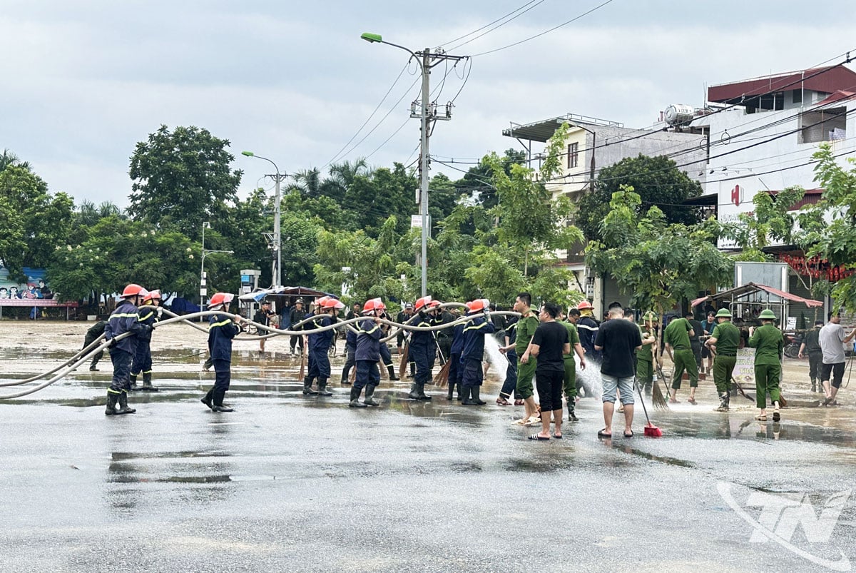 警察はバクカン区文化会館の庭の泥の清掃を支援している。
