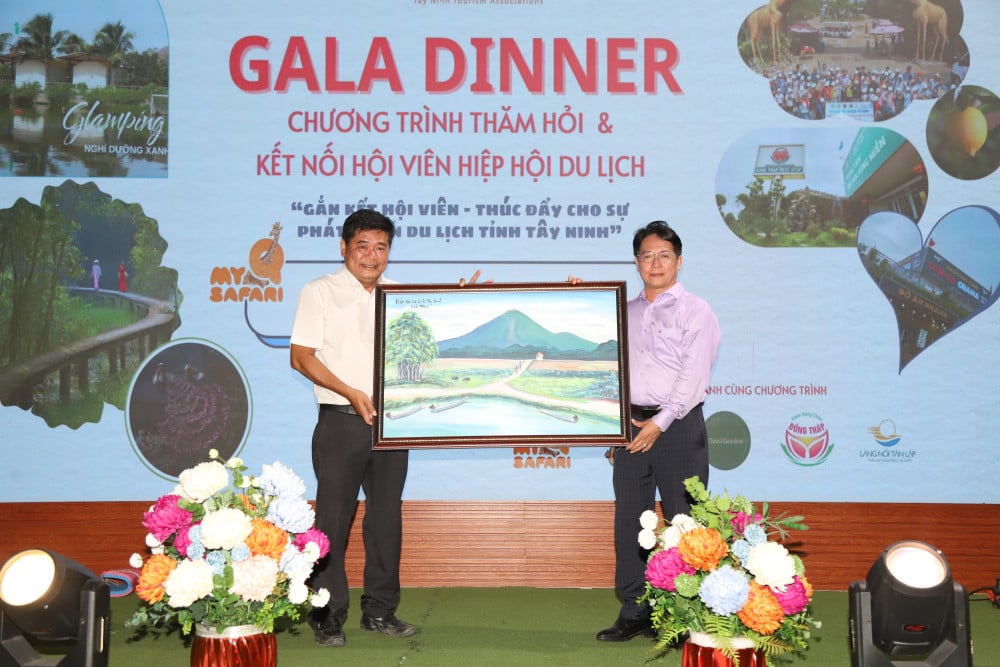 Chủ tịch Hiệp hội Du lịch tỉnh Ngô Trần Ngọc Quốc tặng quà cho ông Lâm Phúc Hoành - Phó Chủ tịch Hiệp hội Du lịch tỉnh, Tổng Giám đốc Mỹ Quỳnh Safari
