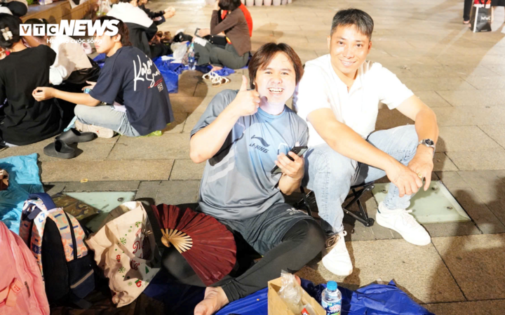 Người dân giữ chỗ trên vỉa hè từ sớm để để chờ tận mắt xem tổng duyệt diễu binh, diễu hành ở TP.HCM dịp 30/4. (Ảnh: Lương Ý)