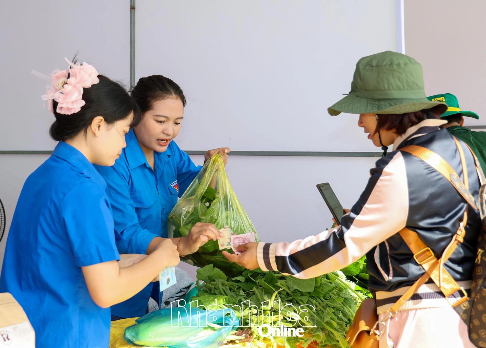Cao Thi Minh Thap (កណ្តាល) លក់ទំនិញអោយអតិថិជន។