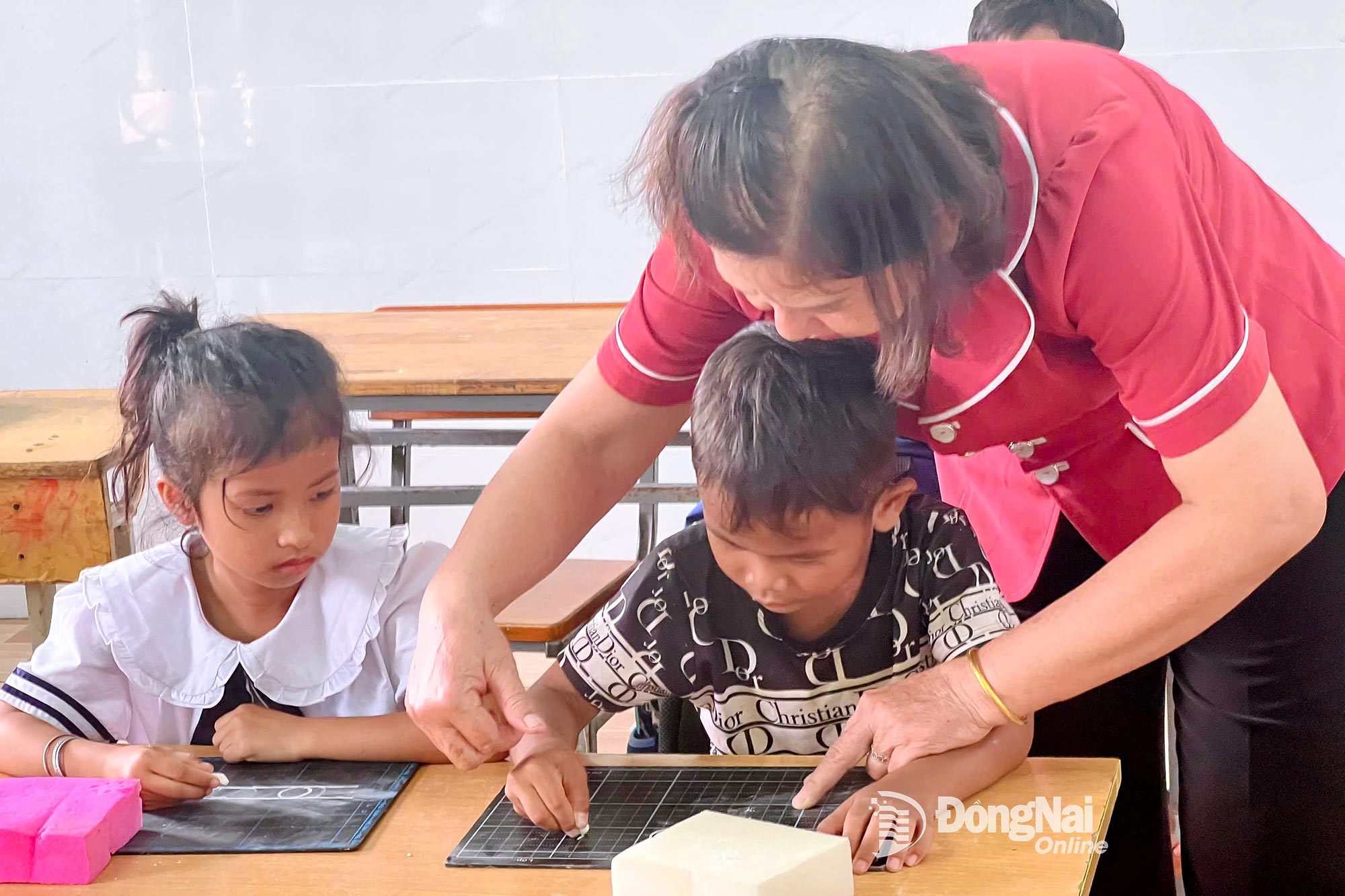 ที่โรงเรียนบุหลิงห์ โรงเรียนประถมและมัธยมศึกษาหลกฟู (ตำบลหลกกวาง) คุณครูเจืองมีฮันห์ กำลังสอนนักเรียนให้คุ้นเคยกับกระดานดำและชอล์ก ภาพโดย: ถั่น เถา