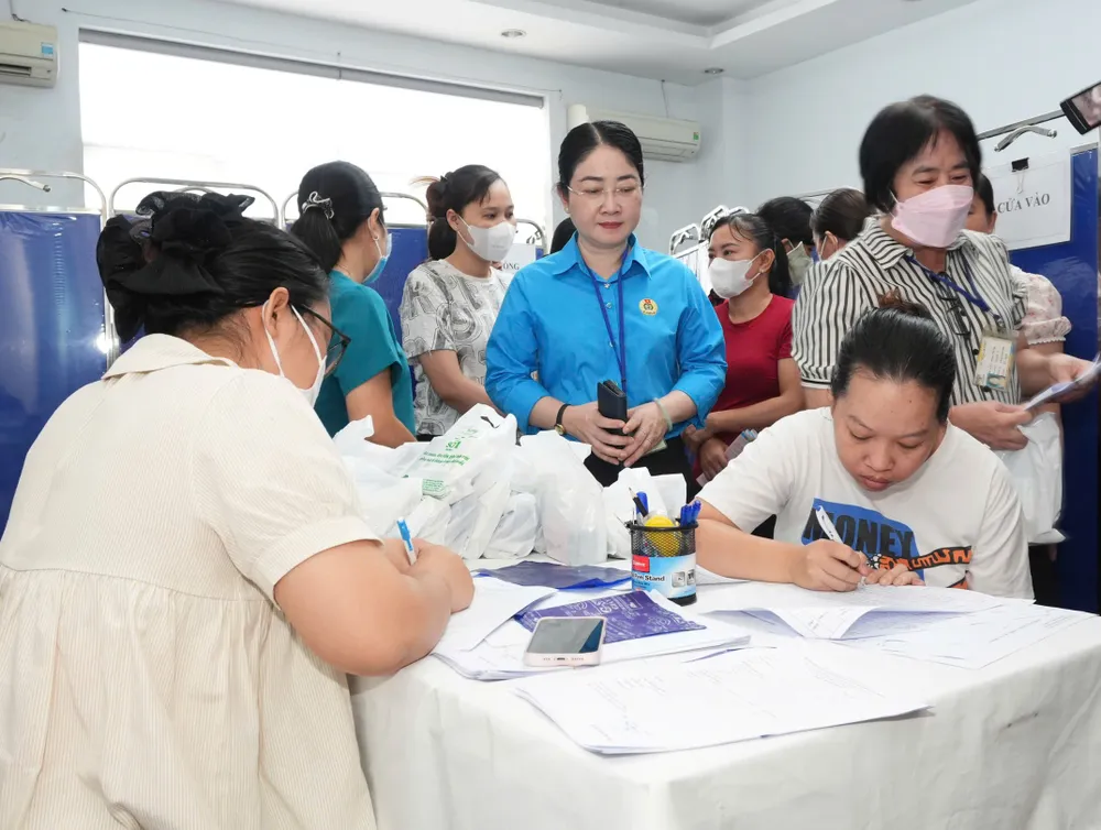 Female workers fill out information to get health check-ups and cancer screening at the program