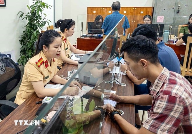 Người dân đến làm thủ tục đăng ký xe tại Công an phường Giảng Võ, thành phố Hà Nội.