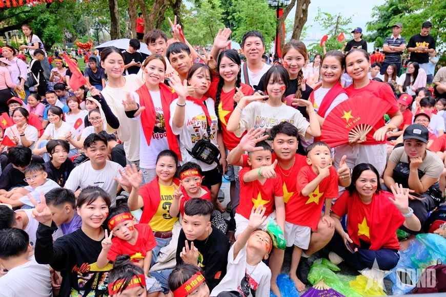 សមុទ្រ​មនុស្ស​មាន​ទង់ជាតិ​ពណ៌​ក្រហម​ដោយ​អន្ទះសា​រង់ចាំ​មើល​ការ​ហាត់សម​ក្បួន​ដង្ហែ​ជា​លើក​ទី​ពីរ។