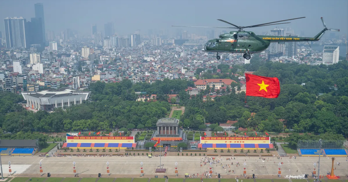 Helicopters carrying the Party flag and the national flag fly over Ba Dinh Square
