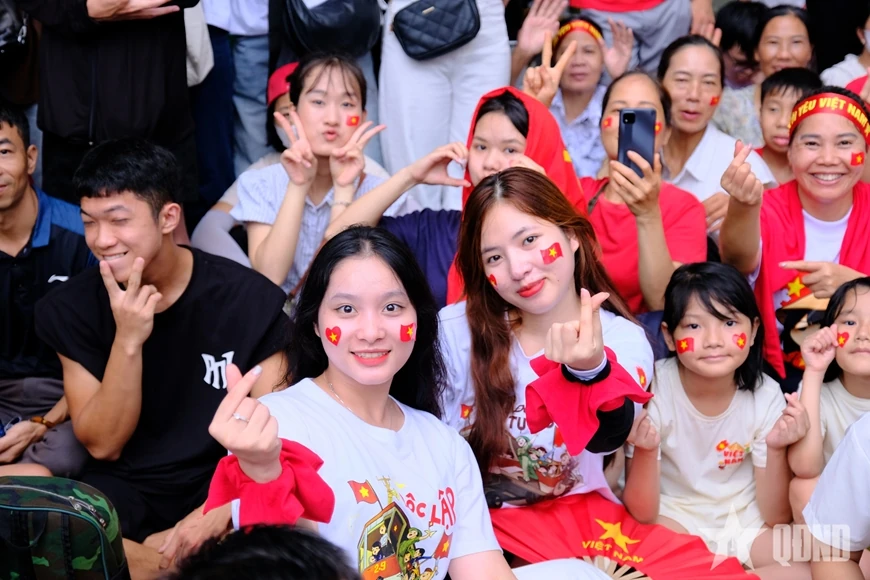 សមុទ្រ​មនុស្ស​មាន​ទង់ជាតិ​ពណ៌​ក្រហម​ដោយ​អន្ទះសា​រង់ចាំ​មើល​ការ​ហាត់សម​ក្បួន​ដង្ហែ​ជា​លើក​ទី​ពីរ។