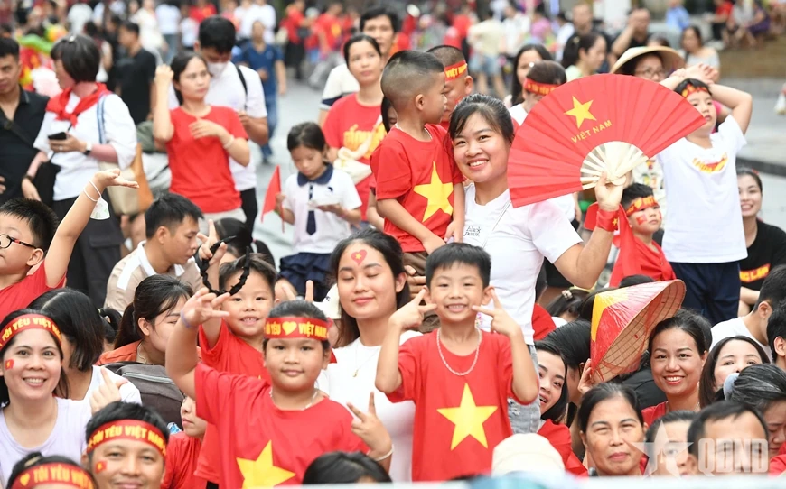 សមុទ្រ​មនុស្ស​មាន​ទង់ជាតិ​ពណ៌​ក្រហម​ដោយ​អន្ទះសា​រង់ចាំ​មើល​ការ​ហាត់សម​ក្បួន​ដង្ហែ​ជា​លើក​ទី​ពីរ។