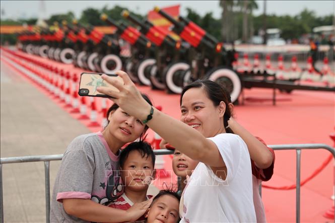 ผู้คนและนักท่องเที่ยวต่างถ่ายรูปกับพลุพิธี A80 อย่างสนุกสนาน