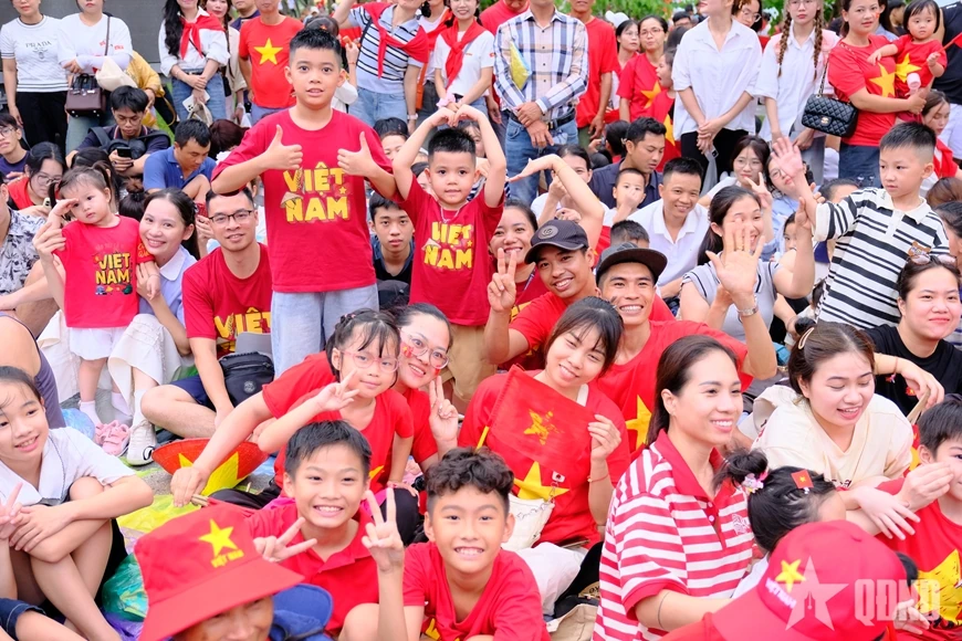 សមុទ្រ​មនុស្ស​មាន​ទង់ជាតិ​ពណ៌​ក្រហម​ដោយ​អន្ទះសា​រង់ចាំ​មើល​ការ​ហាត់សម​ក្បួន​ដង្ហែ​ជា​លើក​ទី​ពីរ។
