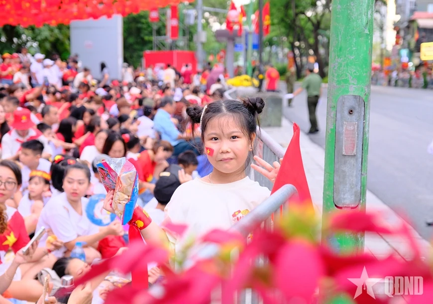 សមុទ្រ​មនុស្ស​មាន​ទង់ជាតិ​ពណ៌​ក្រហម​ដោយ​អន្ទះសា​រង់ចាំ​មើល​ការ​ហាត់សម​ក្បួន​ដង្ហែ​ជា​លើក​ទី​ពីរ។