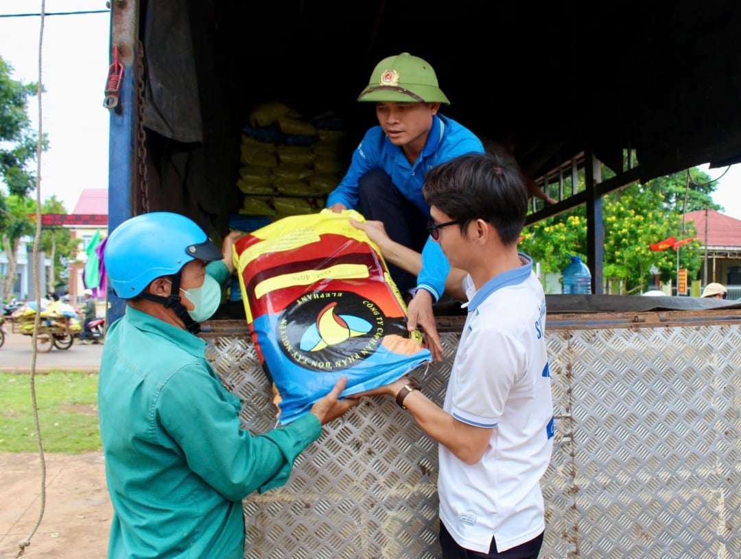 Đại diện Công ty TNHH Xuất nhập khẩu 2-9 Đắk Lắk trao phân bón hỗ trợ nông dân trong xã.