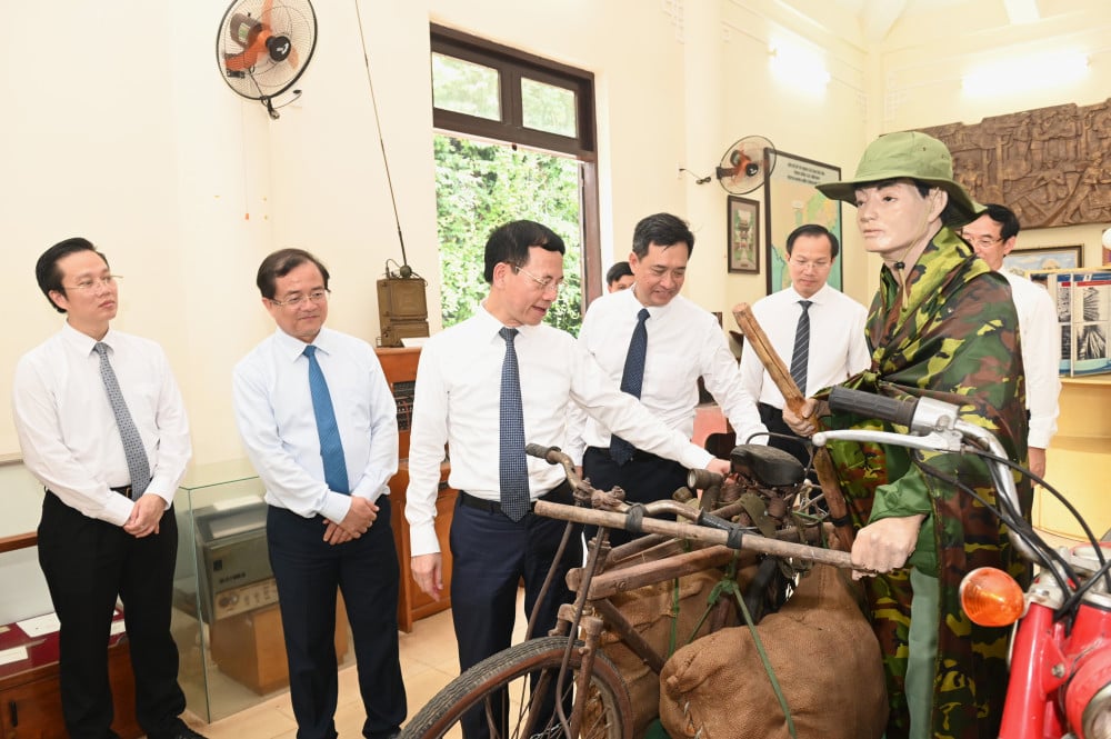 Bộ trưởng Bộ KH&CN Nguyễn Mạnh Hùng và các lãnh đạo tỉnh tham quan mô hình hoạt động giao bưu vận trong Nhà truyền thống Khu Căn cứ Ban GBV và Ban TTLL TWCMN