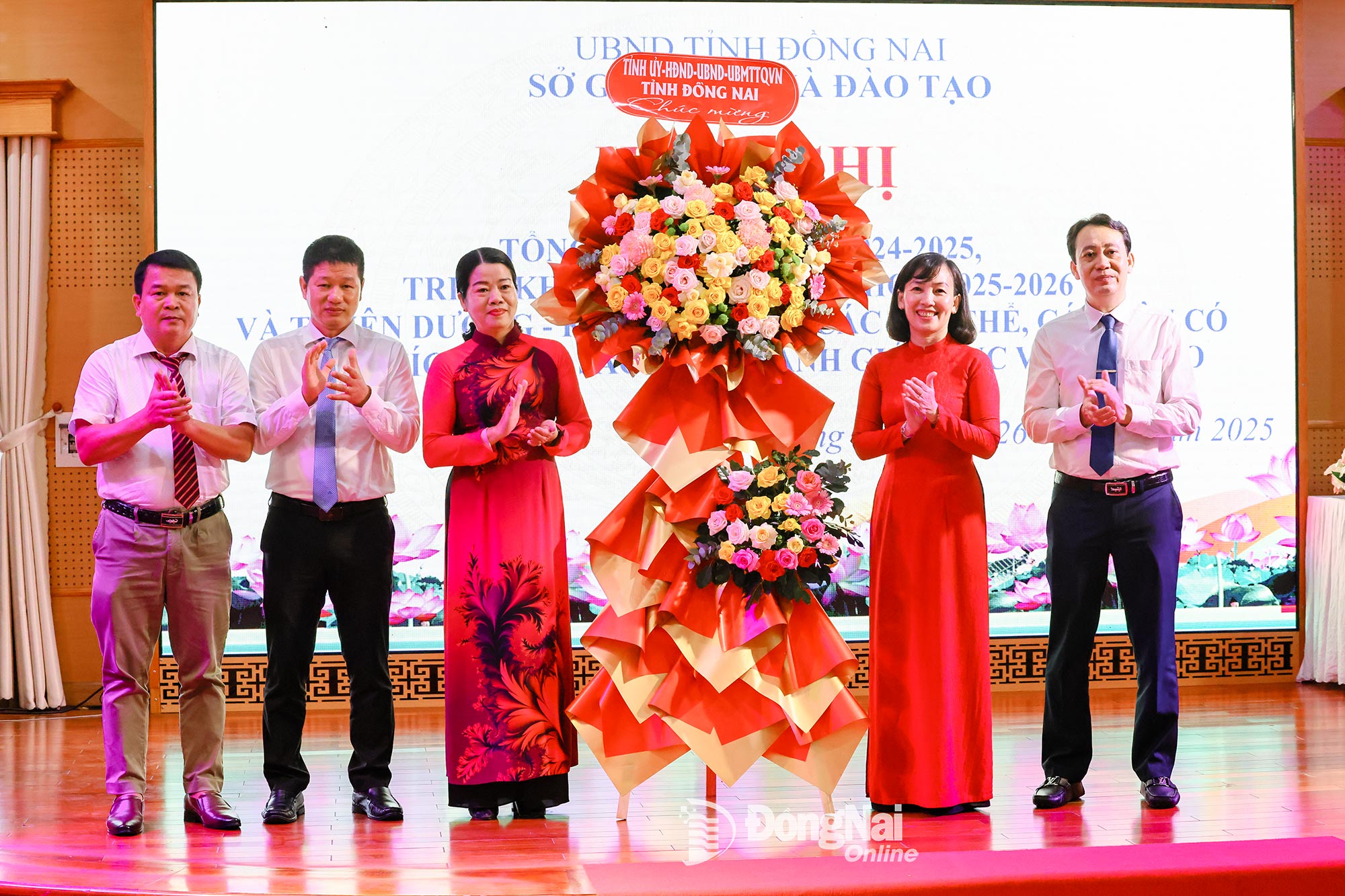 Phó Chủ tịch Ủy ban MTTQ Việt Nam tỉnh Đồng Nai Lưu Thị Hà trao lẵng hoa của Tỉnh ủy, HĐND, UBND, Ủy ban MTTQ Việt Nam tỉnh chúc mừng ngành Giáo dục và Đào tạo tỉnh. Ảnh: Công Nghĩa