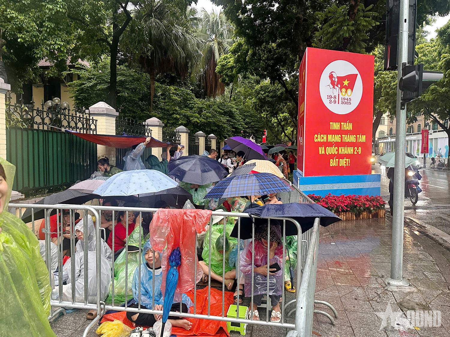 A pesar de la lluvia, la gente extendió lonas para reservar asientos para ver el ensayo del desfile A80.