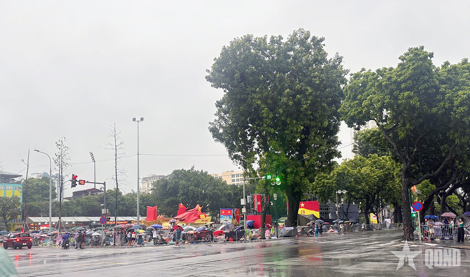 A pesar de la lluvia, la gente extendió lonas para reservar asientos para ver el ensayo del desfile A80.