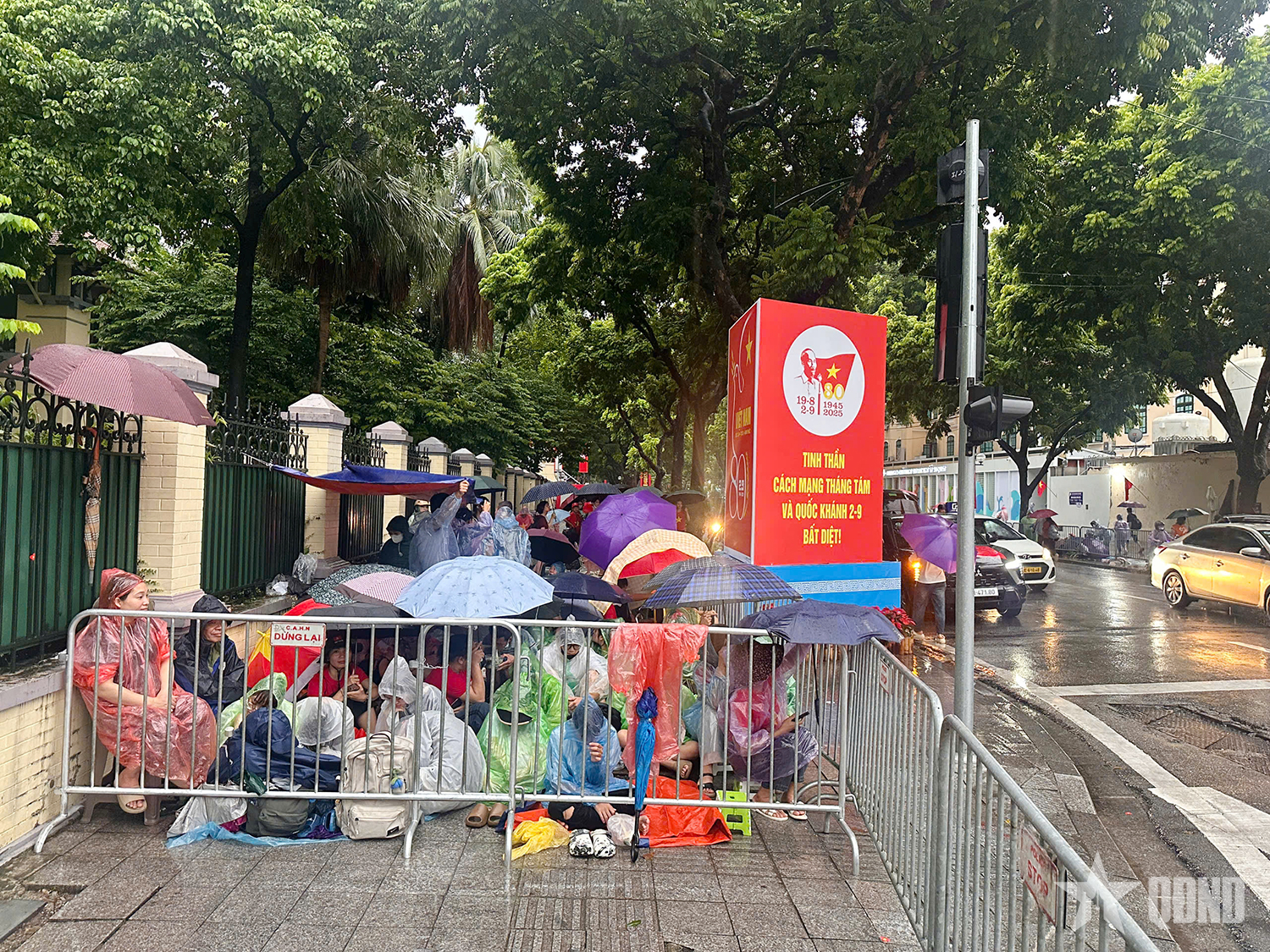 A pesar de la lluvia, la gente extendió lonas para reservar asientos para ver el ensayo del desfile A80.