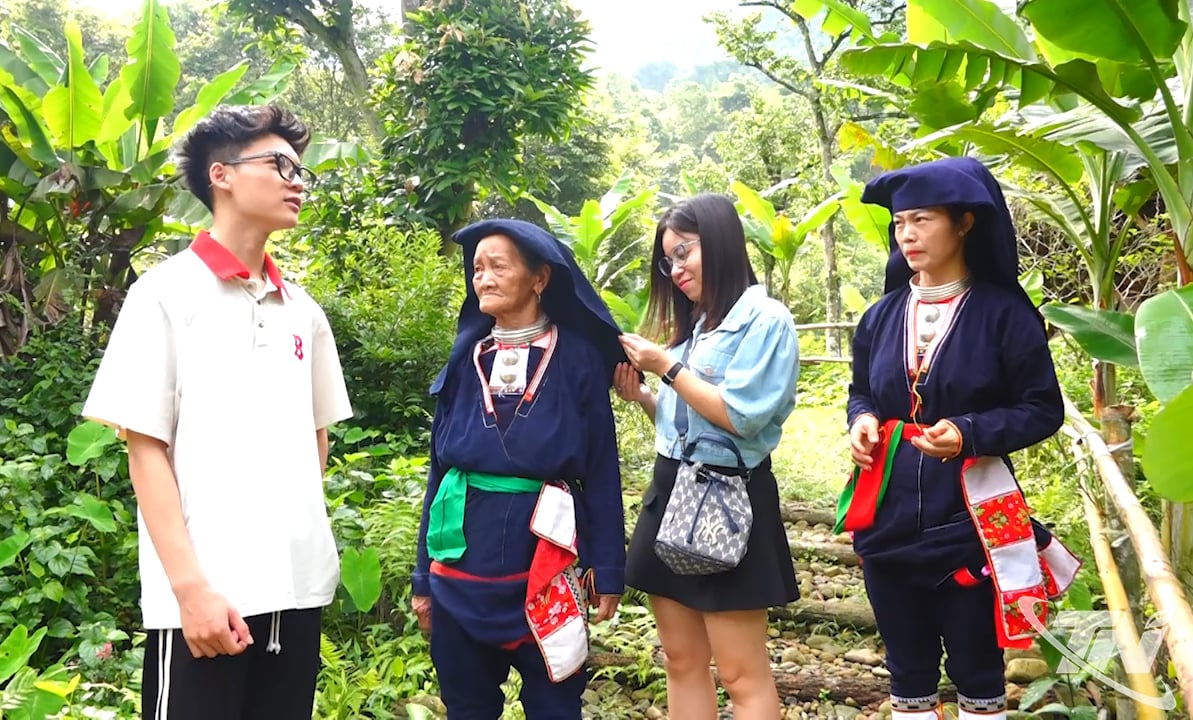 Du khách thích thú tìm hiểu trang phục của người Dao quần chẹt.