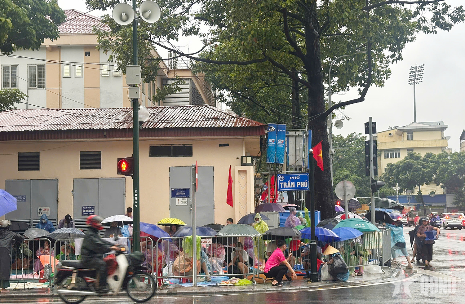 A pesar de la lluvia, la gente extendió lonas para reservar asientos para ver el ensayo del desfile A80.
