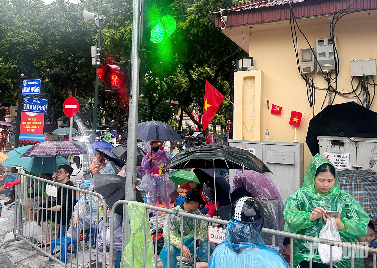 A pesar de la lluvia, la gente extendió lonas para reservar asientos para ver el ensayo del desfile A80.