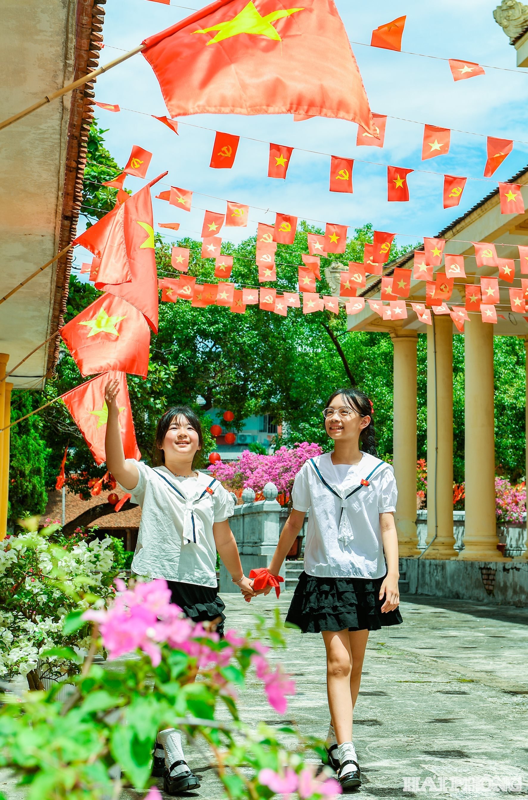 Các bạn nhỏ thích thú đi dưới bóng cờ ho