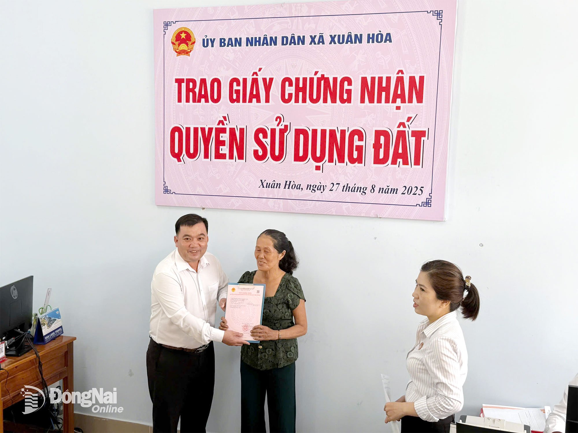 Phó Chủ tịch UBND xã Xuân Hòa Nguyễn Đức Tiến trao sổ đỏ cho bà Ngô Thị Lựa Ảnh: Hưng Cát