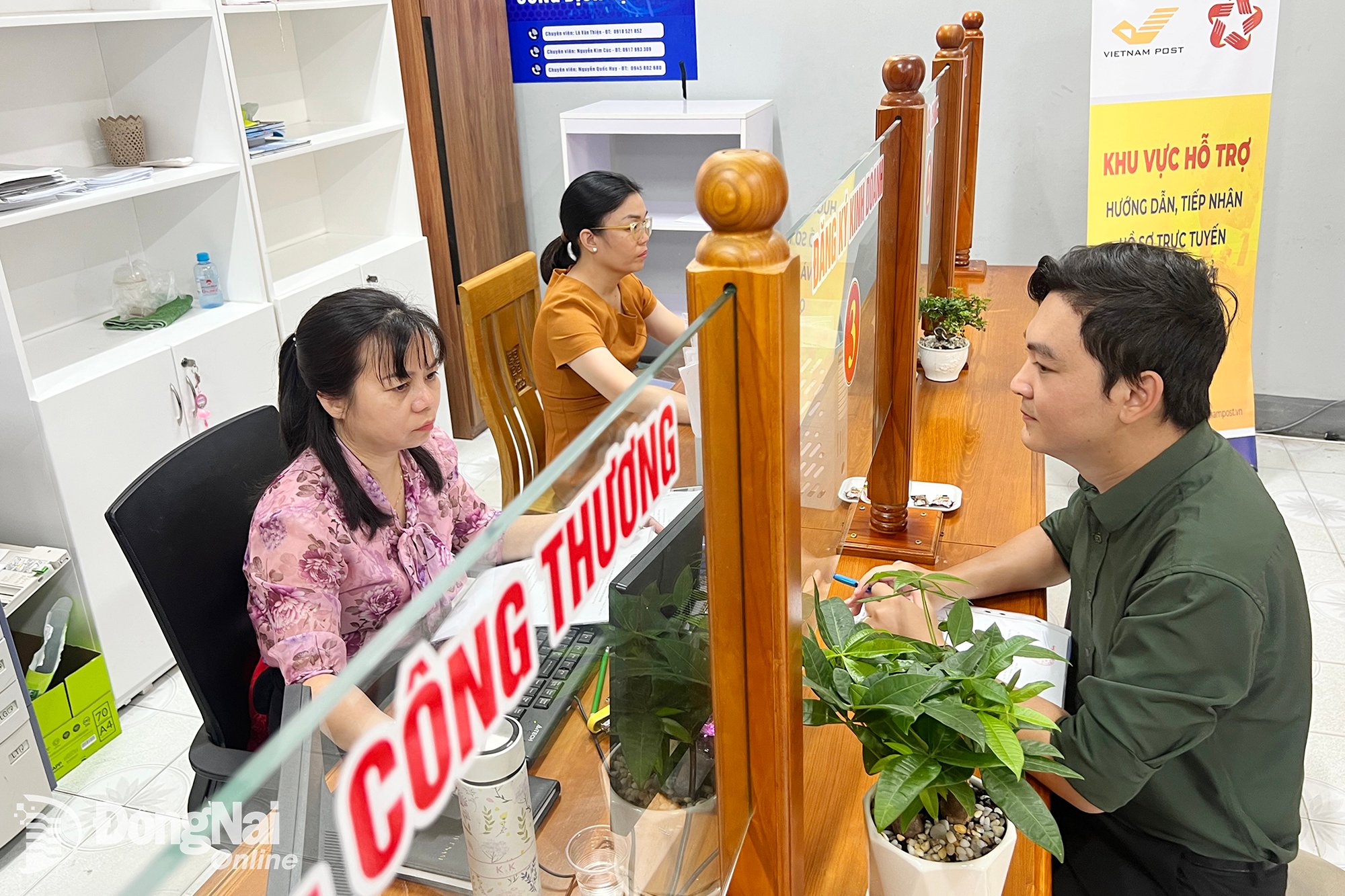 Personas realizan trámites administrativos en línea en el sector industrial y comercial en el Centro de Servicios de Administración Pública del distrito de Ho Nai, provincia de Dong Nai. Foto: Hai Quan