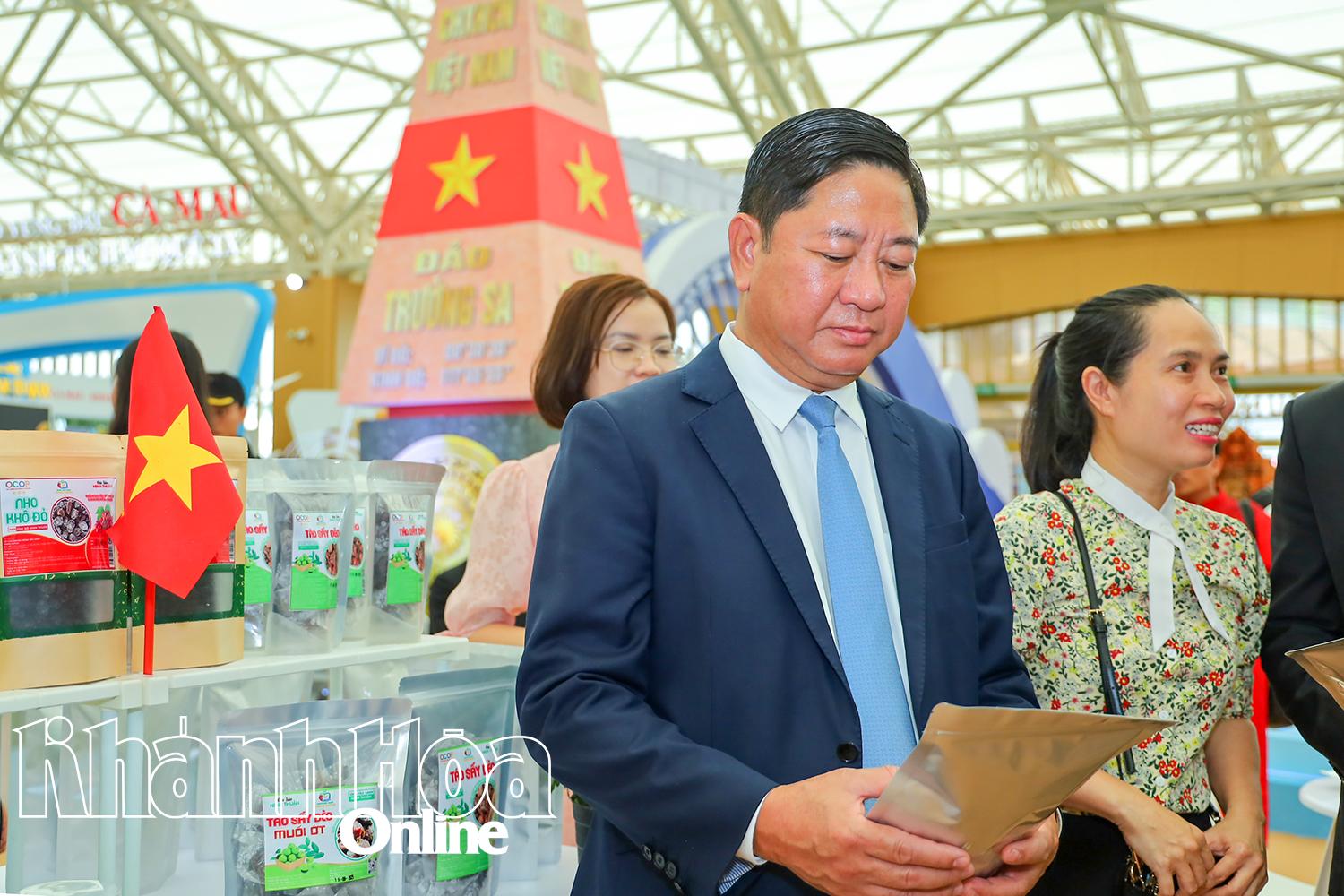 Đồng chí Trần Quốc Nam xem sản phẩm đặc trưng của tỉnh Khánh Hòa giới thiệu tại triển lãm.