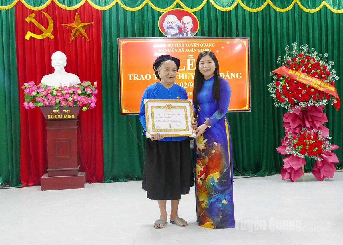 La camarada Le Thi Thanh Tra, miembro del Comité Provincial del Partido, vicepresidenta del Consejo Popular Provincial, entregó la insignia de miembro del Partido de 60 años a la miembro del Partido Hoang Thi Chuoc, célula del Partido de la aldea de Chang, Comité del Partido de la comuna de Xuan Giang.