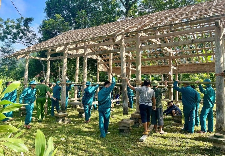 Lực lượng chức năng hỗ trợ gia đình dựng nhà tạm ở vị trí an toàn.