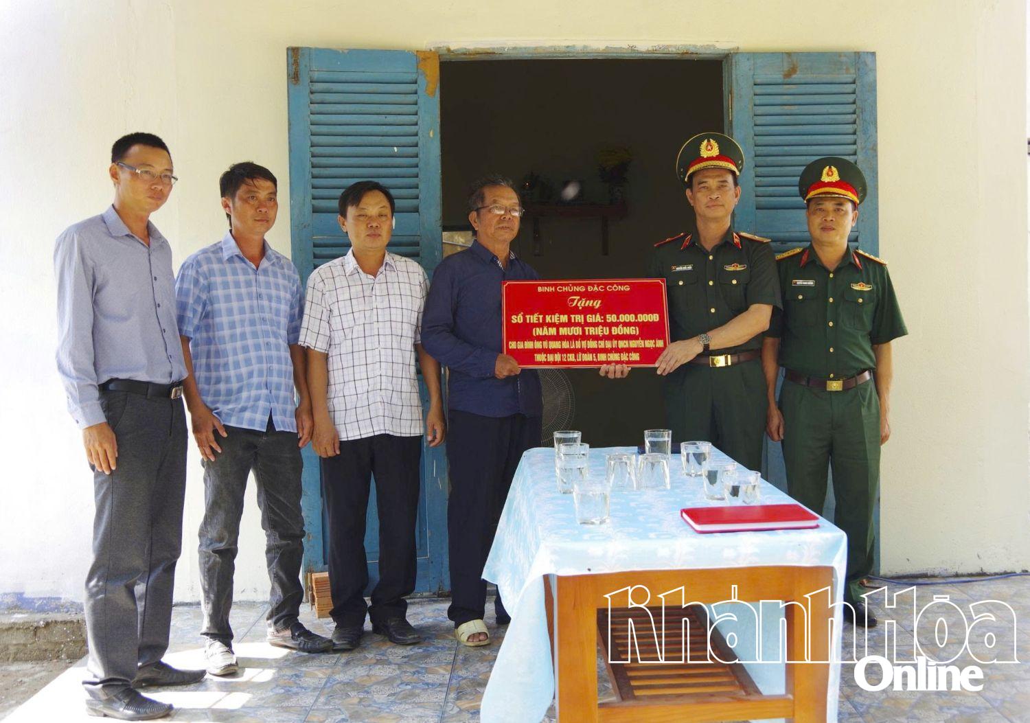 Thiếu tướng Nguyễn Quốc Duẩn trao tặng sổ tiết kiệm cho gia đình quân nhân Nguyễn Ngọc Ánh.