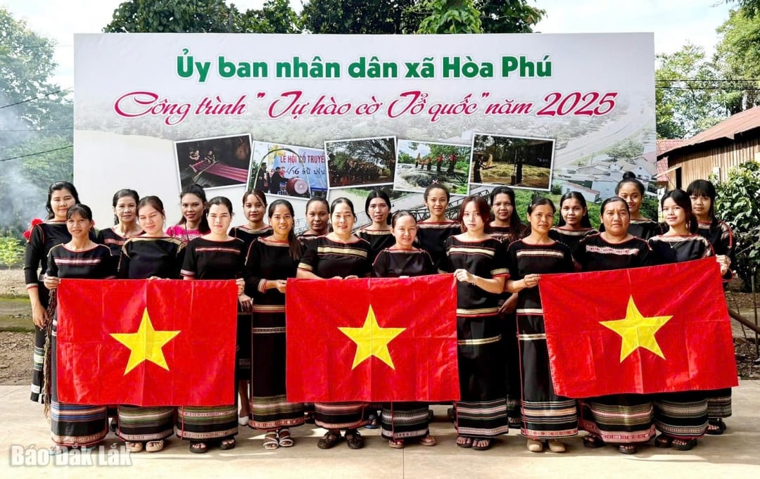 Ethnic minority women take souvenir photos next to the National Flag Pride project in 2025 in Hoa Phu commune.